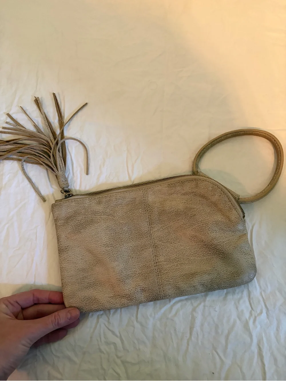 HOBO Sable wristlet in a tan/gold color with tassel